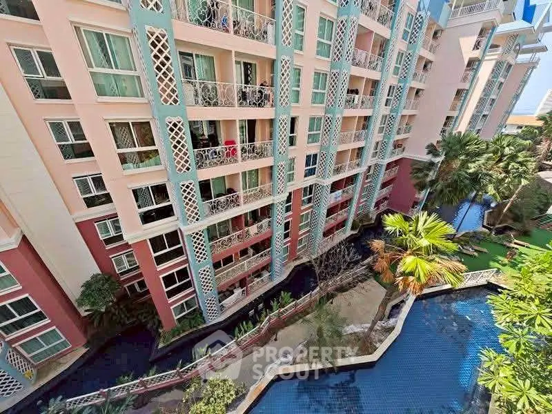 Stunning view of a modern apartment complex with lush gardens and a pool.