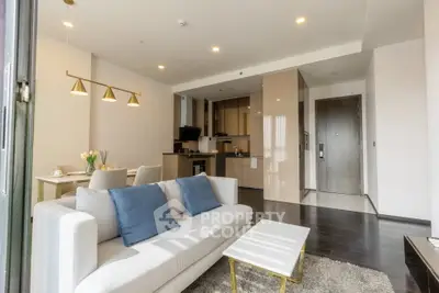 Modern living room with open kitchen and stylish decor in a contemporary apartment.