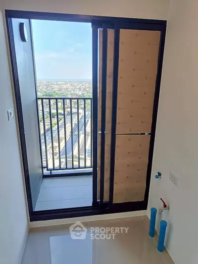 Modern apartment balcony with stunning city view and sleek sliding glass door.