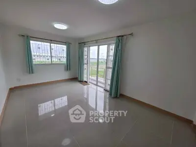 Spacious empty room with large windows and tiled flooring, perfect for customization.