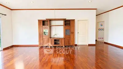 Spacious living room with elegant wooden flooring and built-in wooden cabinet