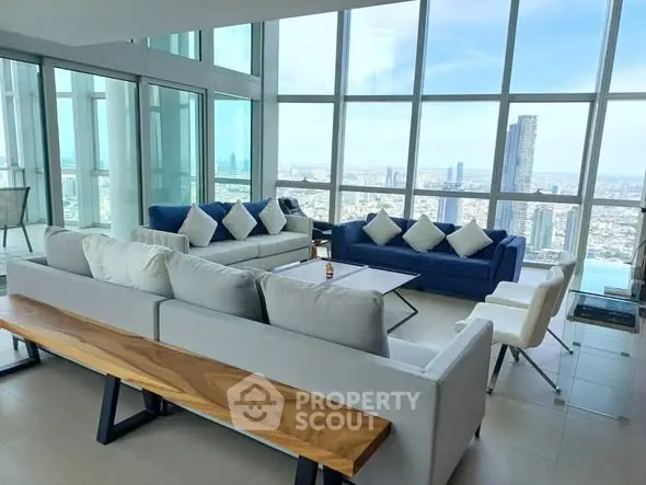 Luxurious high-rise living room with panoramic city views and modern furnishings.