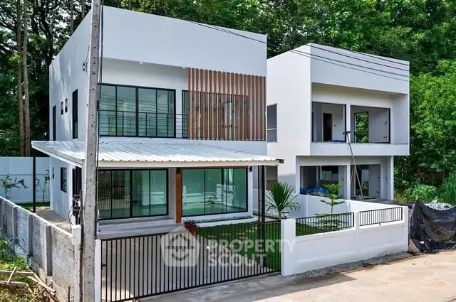 Modern two-story house with sleek design and lush greenery