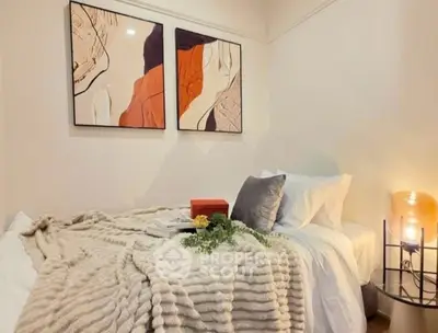 Cozy bedroom with modern art and soft lighting, perfect for relaxation.