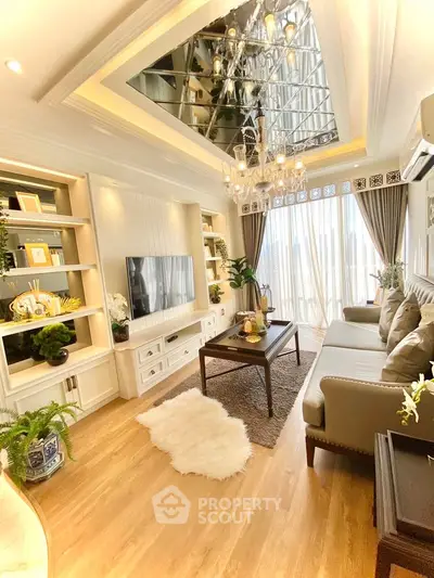Luxurious living room with elegant decor and chandelier, featuring a cozy seating area and large windows.