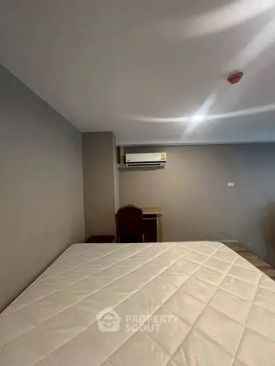 Spacious bedroom with air conditioning and modern furnishings for comfortable living.