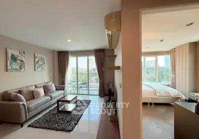 Spacious living room with modern decor and balcony view in a stylish apartment.