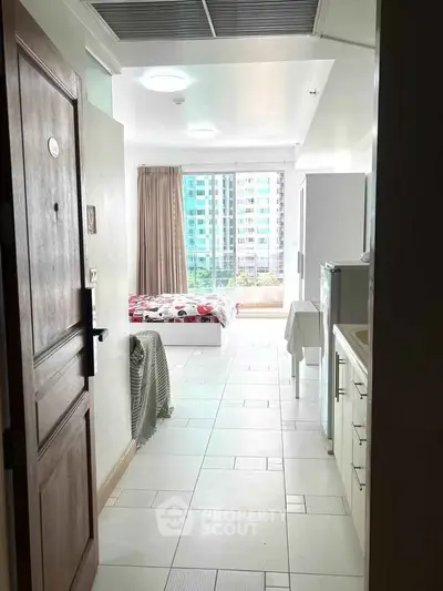 Bright studio apartment with modern furnishings and large windows offering city views.