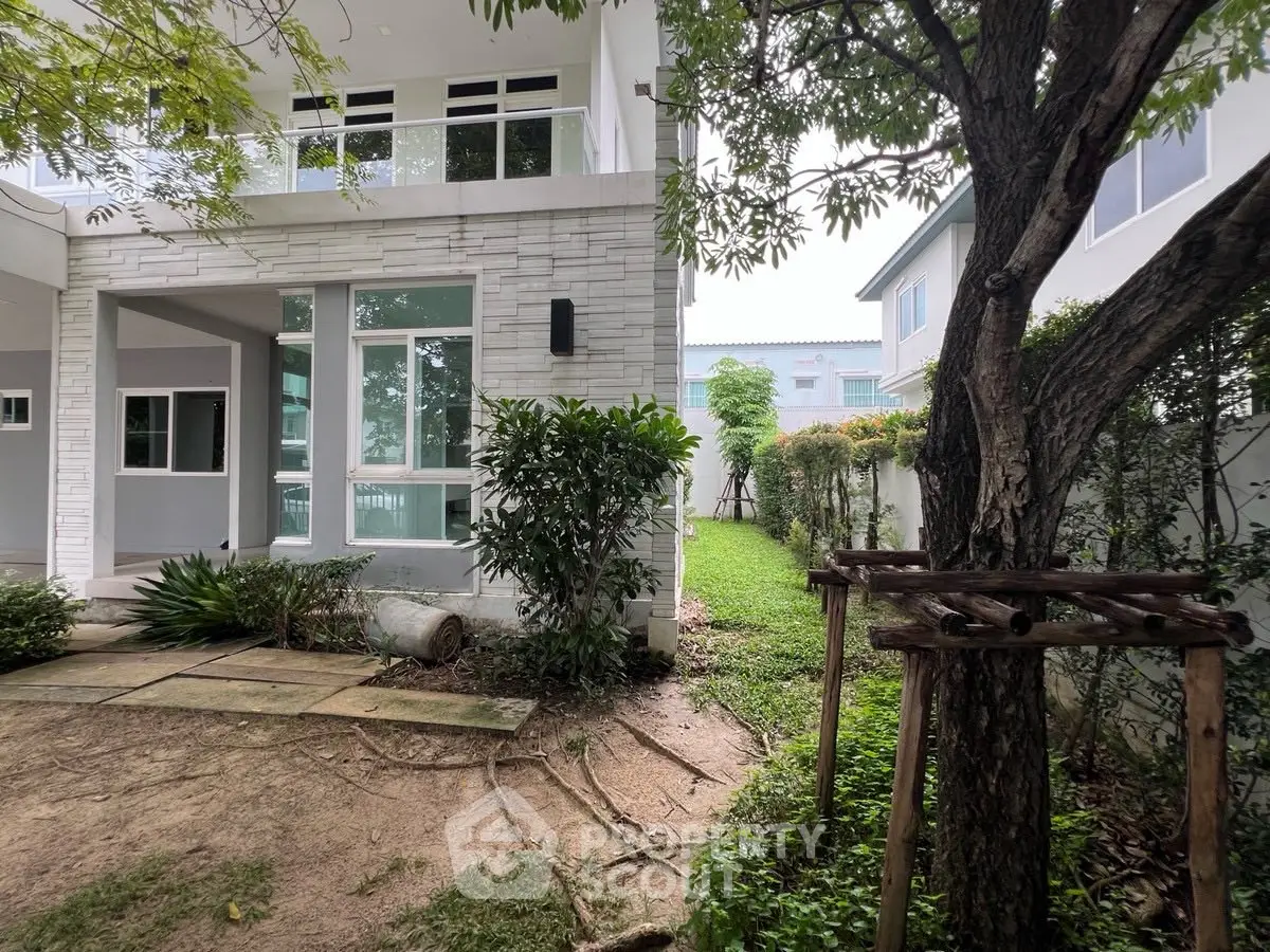 Charming modern house exterior with lush garden and large windows