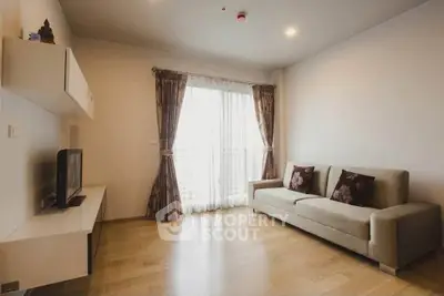 Modern living room with cozy sofa and natural light through large window.
