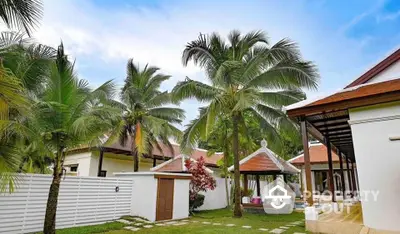 Tropical villa with lush garden and palm trees, perfect for serene living.