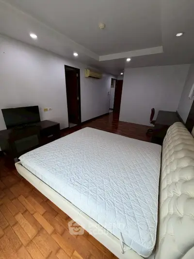 Spacious bedroom with modern decor and hardwood flooring