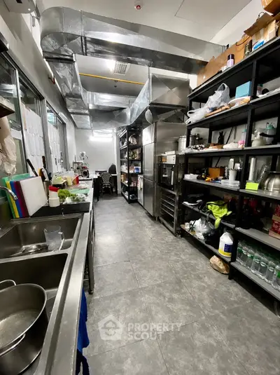 Spacious commercial kitchen with stainless steel appliances and ample storage space.
