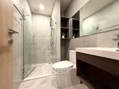 Modern bathroom with glass shower and sleek fixtures in a contemporary home.