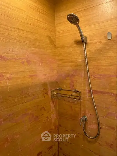 Modern bathroom shower with sleek design and warm wood-like tiles.