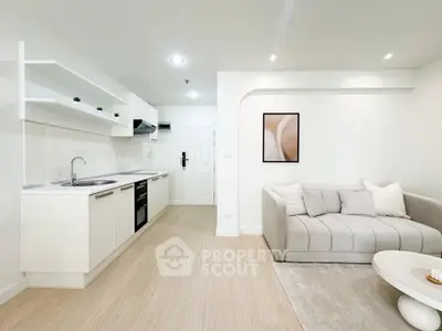 Modern open-layout living room with sleek kitchen, cozy sofa, and stylish decor in a bright, inviting space.