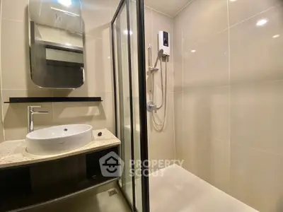 Modern bathroom with sleek shower and stylish vanity in contemporary apartment.