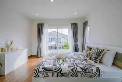 Spacious modern bedroom with large window and stylish decor