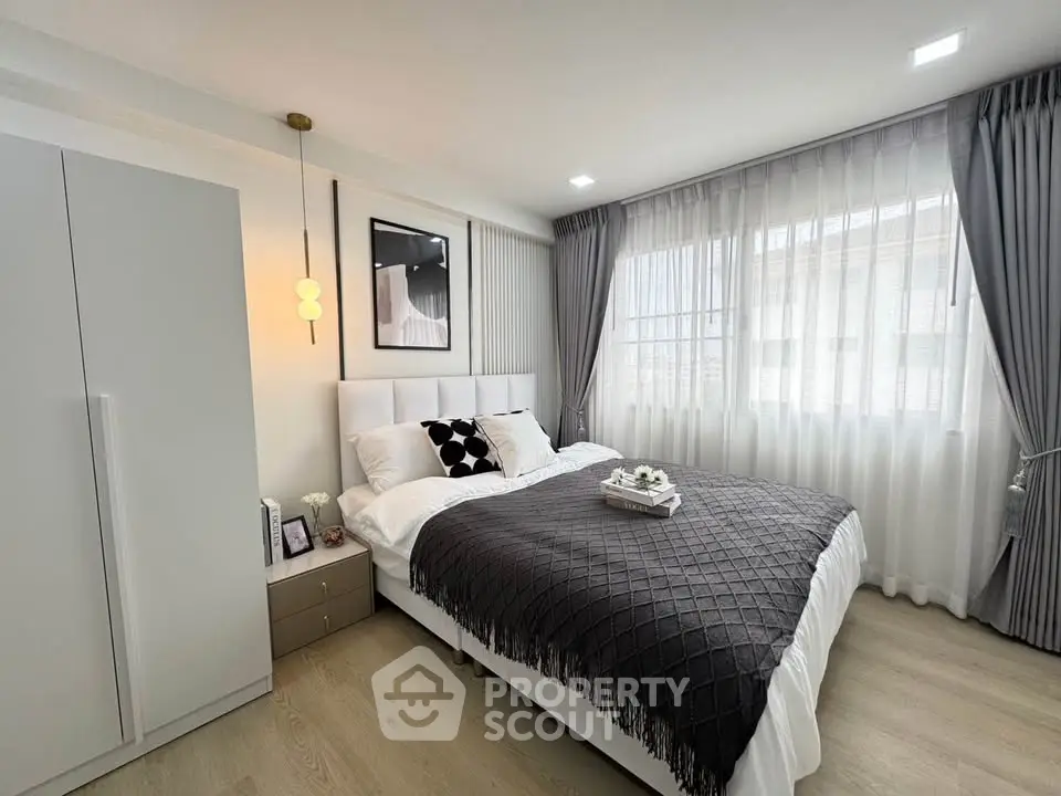 Modern bedroom with stylish decor and large windows for natural light.