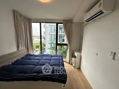 Modern bedroom with large window and air conditioning in urban apartment