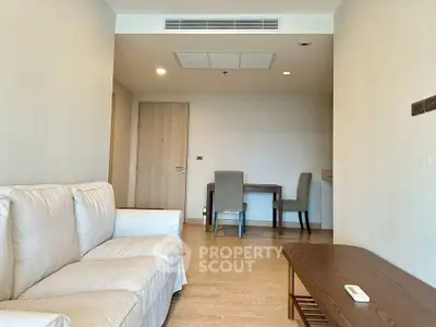Modern living room with cozy sofa and dining area in open layout apartment.