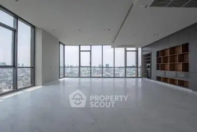 Spacious modern living room with panoramic city views and sleek built-in shelving.