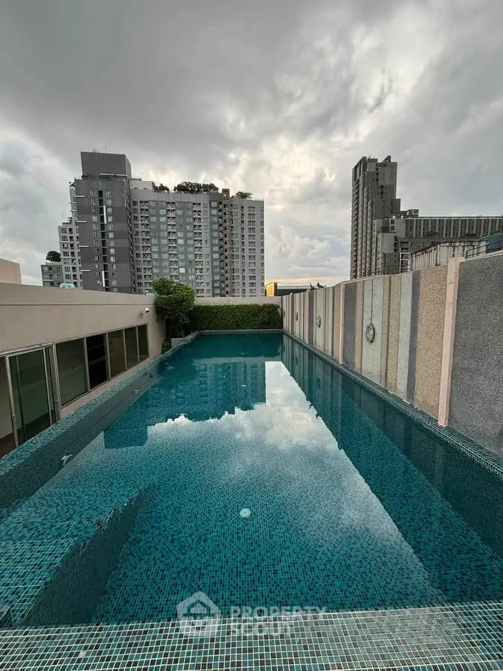 Luxurious rooftop pool with stunning cityscape views in modern high-rise building.