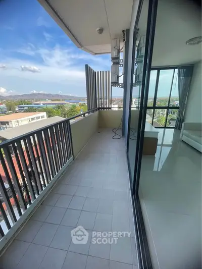 Spacious balcony with stunning city view and modern glass sliding doors.
