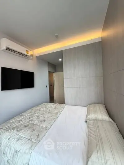 Modern bedroom with sleek design, featuring a wall-mounted TV and air conditioning for ultimate comfort.