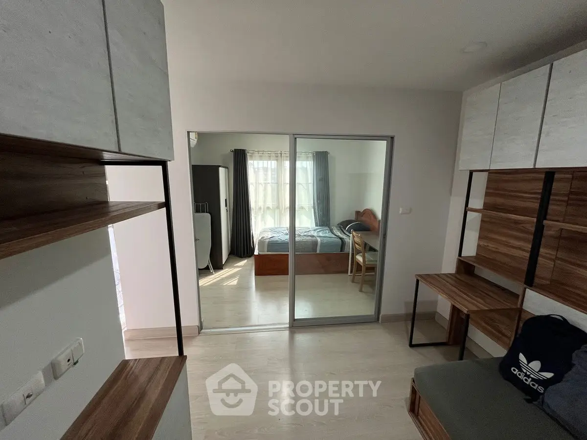 Modern apartment interior with sliding glass doors and stylish wooden furniture