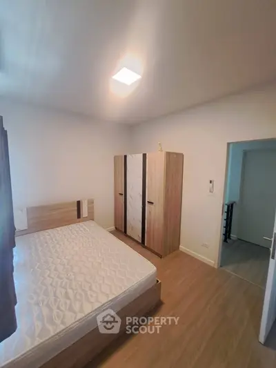 Modern bedroom with wooden flooring and sleek wardrobe design
