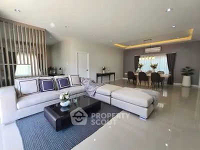 Spacious modern living room with elegant dining area, featuring stylish furniture and contemporary decor.