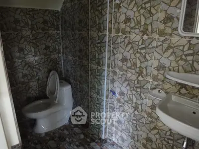 Cozy bathroom with unique stone tile design and modern fixtures.