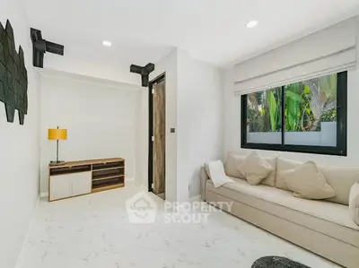 Modern living room with sleek design and large window offering natural light.