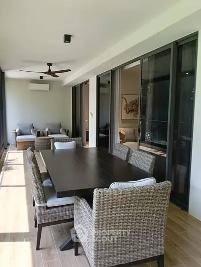 Spacious balcony with elegant dining set and cozy seating area, perfect for outdoor relaxation.