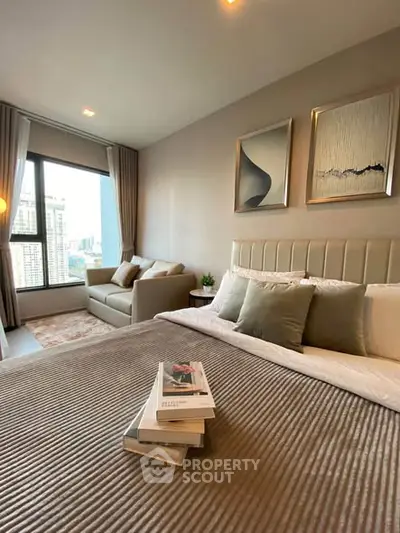 Modern bedroom with city view, cozy seating area, and elegant decor.