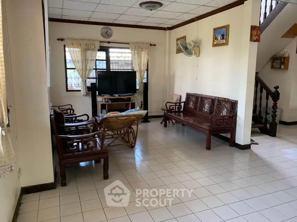 Spacious living room with classic wooden furniture and tiled flooring