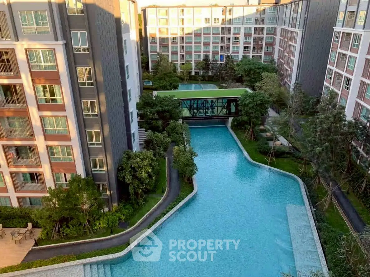 Luxurious residential complex with stunning pool and lush greenery.