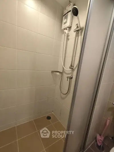 Modern bathroom shower area with sleek tiles and water heater