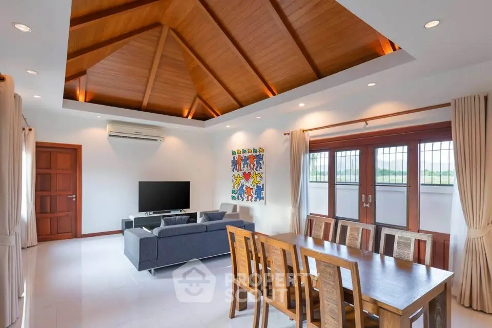 Spacious living room with wooden ceiling and modern furniture, perfect for family gatherings.