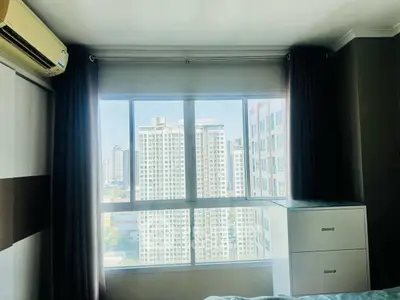 Bright bedroom with large window offering city view in modern apartment