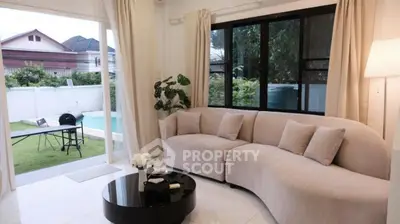 Elegant living room with curved sofa and garden view, perfect for relaxation and entertaining.