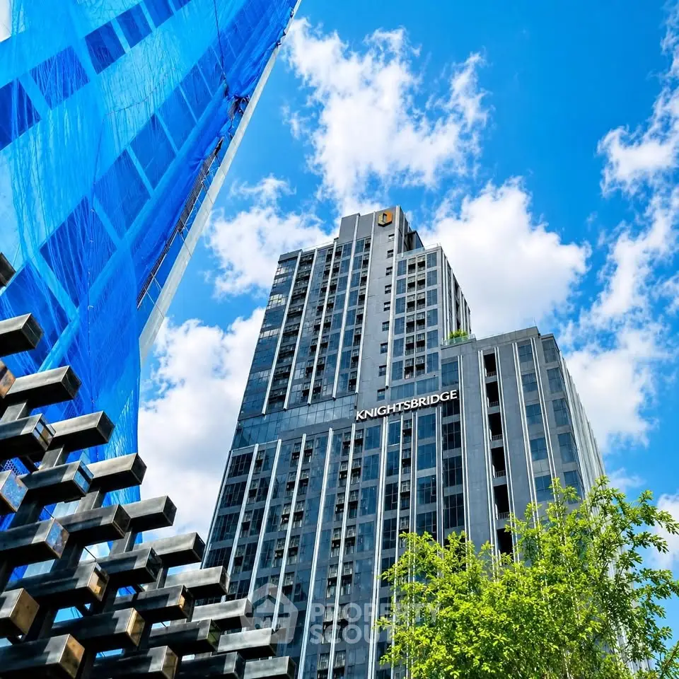 Stunning modern high-rise building with sleek architecture against a vibrant blue sky.