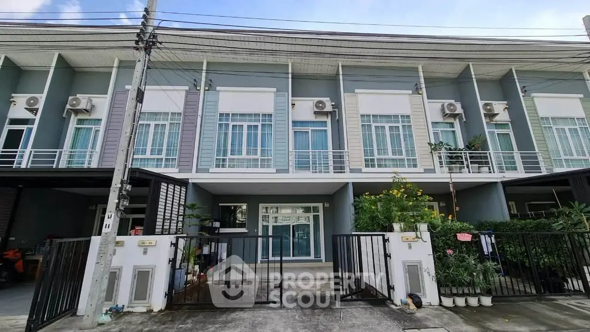 Modern townhouse exterior with gated entrance and large windows, perfect for urban living.