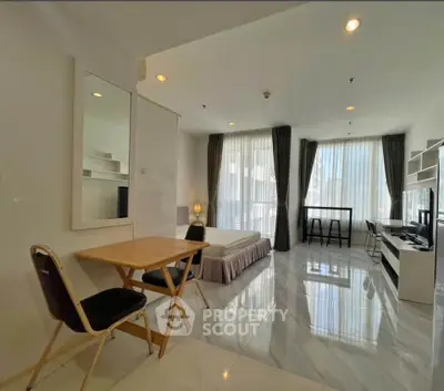Spacious modern studio apartment with elegant furnishings and large windows for natural light.