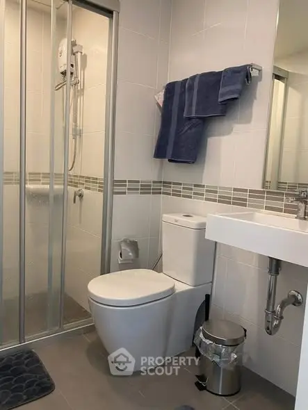 Modern bathroom with shower enclosure and sleek fixtures in a contemporary apartment.