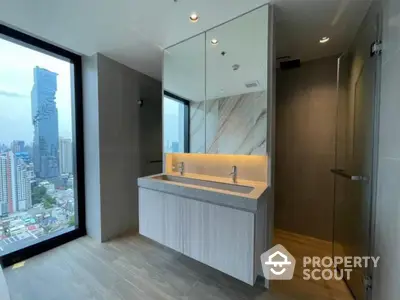 Modern bathroom with dual sinks and stunning city view from high-rise apartment.