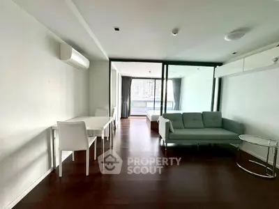 Modern open-plan living room with sleek furniture and large windows for natural light.
