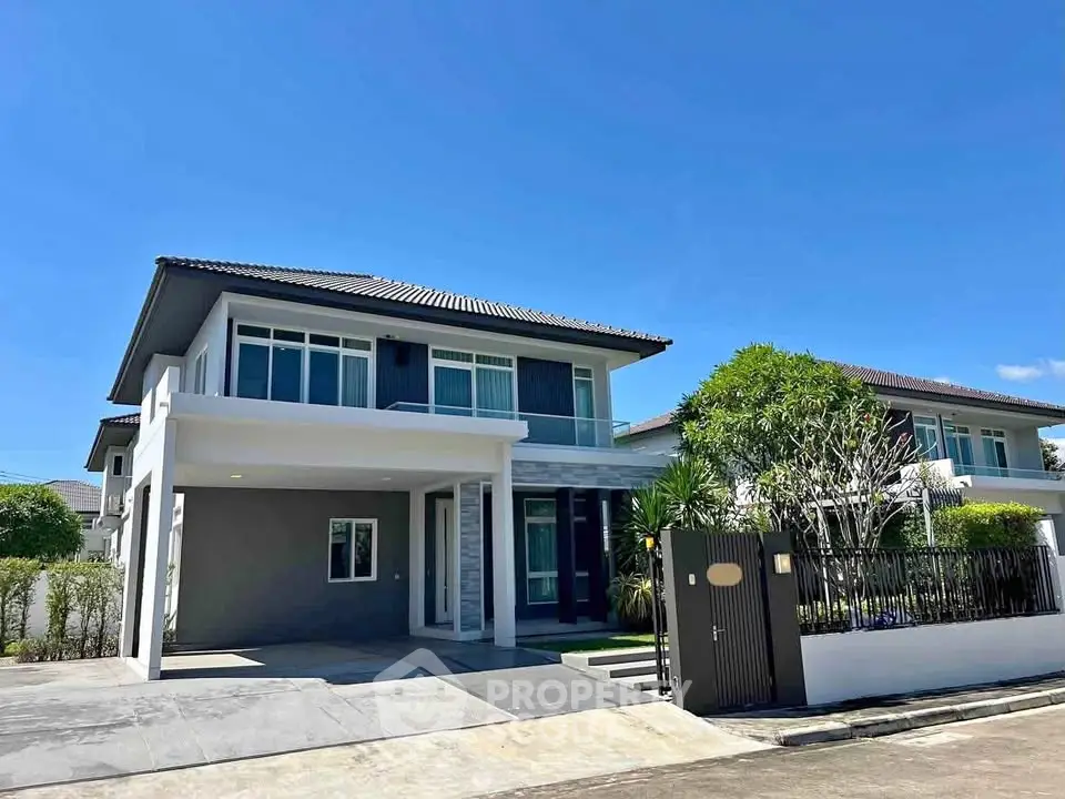 Modern two-story house with sleek design and spacious driveway in a serene neighborhood.