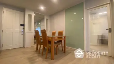 Modern dining area with wooden table and chairs, featuring sleek design and ambient lighting.